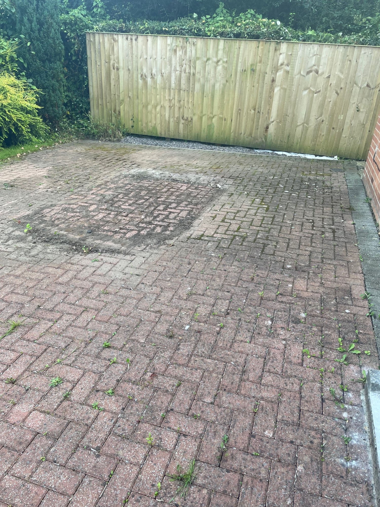 Dirty block paving driveway before pressure washing York — moss, weeds and staining